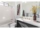 Modern bathroom with dark vanity, bathtub, and updated fixtures at 36038 N Puente Alto Ave, Queen Creek, AZ 85140