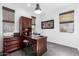 Bright home office features a large desk, built-in shelving, and ample natural light at 36038 N Puente Alto Ave, Queen Creek, AZ 85140