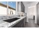 Modern kitchen with gray cabinets, granite countertops and a black farmhouse sink at 36038 N Puente Alto Ave, Queen Creek, AZ 85140