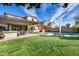 Sprawling backyard with a covered patio, pool, artificial turf, and outdoor seating, creating a serene and inviting outdoor space at 3933 E Alfalfa Dr, Gilbert, AZ 85298