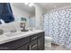 A bathroom featuring double sinks, a mirror, and a shower with blue seashell pattern at 3933 E Alfalfa Dr, Gilbert, AZ 85298