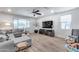 Bright living room featuring a large sectional sofa and wood-look flooring at 3933 E Alfalfa Dr, Gilbert, AZ 85298