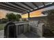 Outdoor built-in kitchen featuring a stainless steel grill and a mini fridge under a pergola at 3933 E Alfalfa Dr, Gilbert, AZ 85298