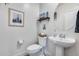 Stylish powder room with a pedestal sink, framed art, and modern fixtures for a chic and functional space at 3933 E Alfalfa Dr, Gilbert, AZ 85298