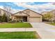 Single-story home with a tan facade, landscaped lawn, and a two-car garage at 4041 E Lexington Ave, Gilbert, AZ 85234