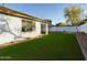 Artificial turf backyard with desert landscaping and a view of a neighboring home at 4229 E Crest Ct, Gilbert, AZ 85298