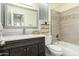 Bathroom with a marble countertop, wood vanity, decorative mirror, and tiled shower-tub combination at 4229 E Crest Ct, Gilbert, AZ 85298