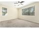 Spacious bedroom featuring neutral carpet, a ceiling fan, and natural light from the window at 4229 E Crest Ct, Gilbert, AZ 85298