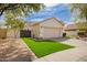 Well-maintained single-story home with a two-car garage and beautiful green synthetic grass at 4229 E Crest Ct, Gilbert, AZ 85298