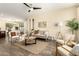 Inviting living room featuring stylish furniture, wood-look floors, a ceiling fan, and plenty of natural light at 4229 E Crest Ct, Gilbert, AZ 85298