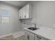 Bright laundry room with white cabinets and a marble countertop at 4257 E John St, Gilbert, AZ 85295