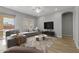 Living room with gray sectional sofa, coffee table and wood-look tile floors at 4257 E John St, Gilbert, AZ 85295