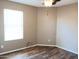 Spacious bedroom with neutral walls, laminate wood flooring, and a ceiling fan at 42659 W Sunland Dr, Maricopa, AZ 85138