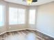 Bright living room with neutral walls, laminate wood flooring, and large windows at 42659 W Sunland Dr, Maricopa, AZ 85138