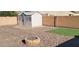 Backyard oasis with fire pit, shed, and artificial turf at 42788 W Martie Lynn Rd, Maricopa, AZ 85138