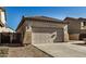 Tan house with tile roof and two-car garage.Landscaped yard at 42788 W Martie Lynn Rd, Maricopa, AZ 85138