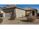 Tan house with tile roof, two-car garage, and desert landscaping at 42788 W Martie Lynn Rd, Maricopa, AZ 85138