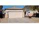 House exterior featuring a two-car garage and well-maintained landscaping at 42788 W Martie Lynn Rd, Maricopa, AZ 85138