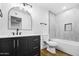 Modern bathroom with dark vanity, white bathtub and grey tile at 4607 E Park St, Phoenix, AZ 85042