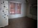 A bedroom with peeling paint and damaged door, showcasing its worn condition and need for renovation at 504 W Baseline Rd, Buckeye, AZ 85326