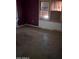 A bedroom in disrepair with a worn floor and damaged walls, with an aged window adding to the room's state at 504 W Baseline Rd, Buckeye, AZ 85326
