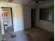 Image shows a bedroom with peeling paint, damaged walls, and a deteriorated bathroom to the side at 504 W Baseline Rd, Buckeye, AZ 85326
