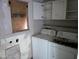 A laundry room with dated appliances and peeling paint, showing clear signs of neglect and deferred maintenance at 504 W Baseline Rd, Buckeye, AZ 85326