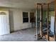 A living room with damaged walls and floor, showing signs of neglect and the need for extensive renovation at 504 W Baseline Rd, Buckeye, AZ 85326