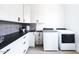 Modern laundry room with white cabinets and dark countertops at 5918 E Tina Dr, Phoenix, AZ 85054