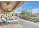 Relaxing covered patio with pavers, seating area, and desert landscaping at 5927 E Sienna Bouquet Pl, Cave Creek, AZ 85331