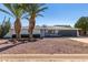 Mid-century modern home with a landscaped front yard and two palm trees at 7513 E Minnezona Ave, Scottsdale, AZ 85251