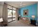 Bright bedroom with sliding glass doors to patio and soothing blue accent wall at 8 Biltmore Est # 123, Phoenix, AZ 85016