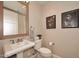 Elegant powder room with pedestal sink, toilet, and framed art at 8 Biltmore Est # 123, Phoenix, AZ 85016