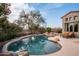 Inviting pool with a rock waterfall feature and patio seating at 9111 E Mountain Spring Rd, Scottsdale, AZ 85255