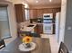 Well-equipped kitchen with brown cabinets, granite countertops, and modern appliances at 10728 W Irma Ln, Sun City, AZ 85373