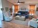 Relaxing living room with hardwood floors, comfortable seating, and a large flat-screen TV at 10728 W Irma Ln, Sun City, AZ 85373