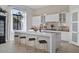 Modern kitchen with white cabinets, large island, and brick backsplash at 10929 E North Ln, Scottsdale, AZ 85259