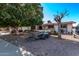Single story home with a gravel driveway and mature trees at 11840 N 49Th Ave, Glendale, AZ 85304