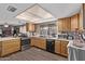 Galley style kitchen with wood cabinets and modern appliances at 11840 N 49Th Ave, Glendale, AZ 85304