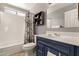 Clean bathroom with white tile, navy vanity, and birch curtain at 1243 E Avenida Grande --, Casa Grande, AZ 85122