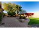 Landscaped backyard with brick pavers, palm trees, and artificial turf at 17770 W Cottonwood Ln, Goodyear, AZ 85338