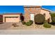 Tan two-story house with stone accents, two-car garage, and nicely landscaped yard at 17770 W Cottonwood Ln, Goodyear, AZ 85338