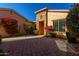 Front entrance with stone accents, red flowers, and a brick courtyard at 17770 W Cottonwood Ln, Goodyear, AZ 85338