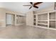 Spacious living room with tile floors, built-in shelving, and ceiling fan at 17770 W Cottonwood Ln, Goodyear, AZ 85338