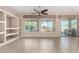 Living room with tile floors, built-in shelving, ceiling fan, and sliding glass doors at 17770 W Cottonwood Ln, Goodyear, AZ 85338