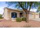 Tan stucco house with two-car garage and mature tree at 2101 S Yellow Wood -- # 75, Mesa, AZ 85209