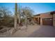 View of home exterior with a two-car garage and cacti at 29991 N 78Th Pl, Scottsdale, AZ 85266