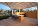 Outdoor kitchen with granite countertops, built-in grill, and pergola cover at 29991 N 78Th Pl, Scottsdale, AZ 85266
