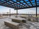 Outdoor kitchen featuring a built-in grill and dining table in a community park at 37389 W San Clemente St, Maricopa, AZ 85138