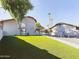 Spacious backyard with putting green, patio, and artificial turf at 4530 W Misty Willow Ln, Glendale, AZ 85310
